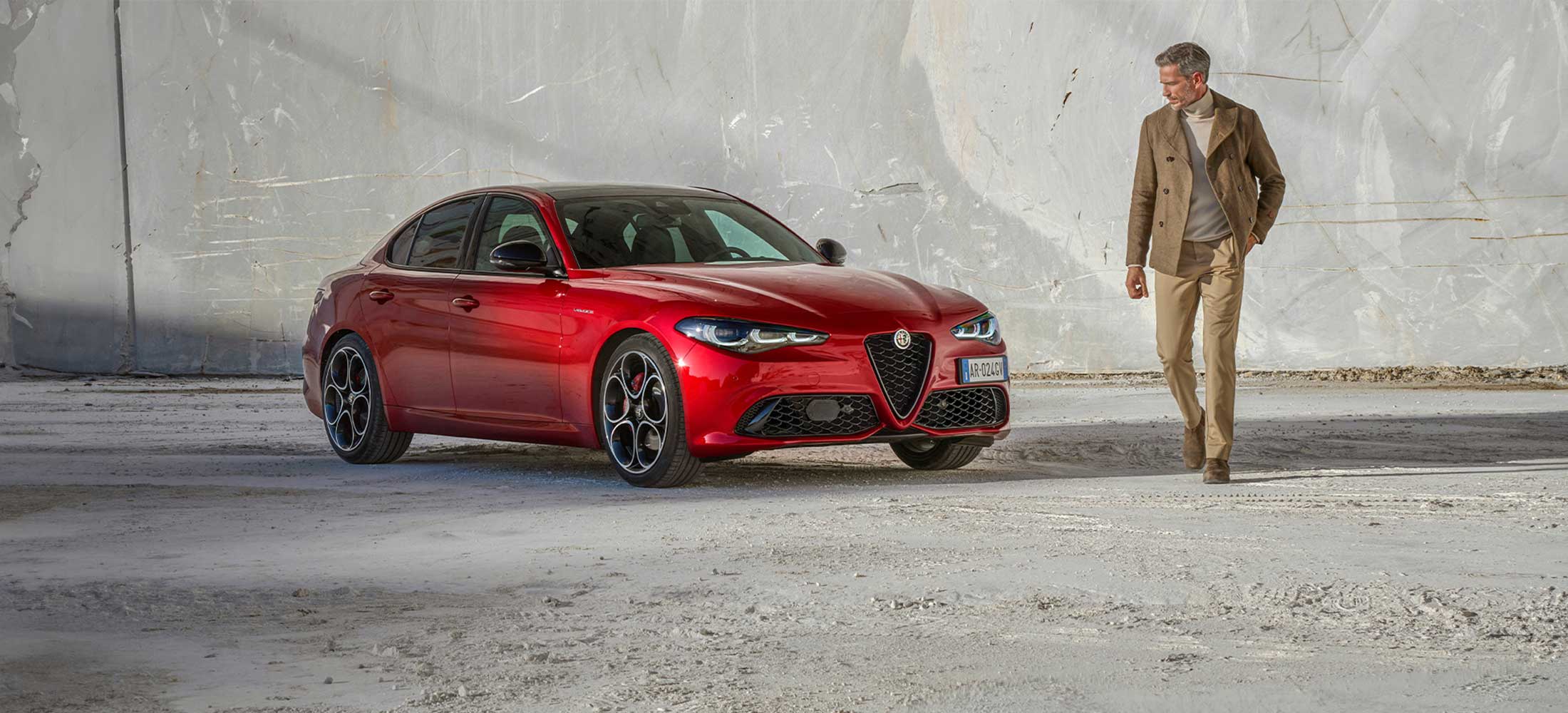 Alfa Romeo Giulia neben modisch gekleidetem Mann